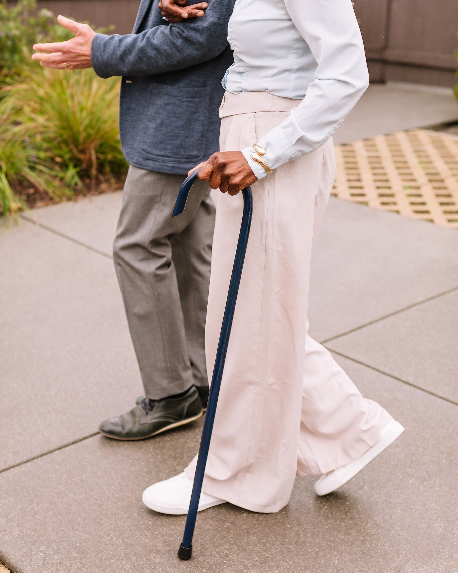 Person holding a Navy Blue 7/8" Classic American Walking Cane outdoors on a sidewalk