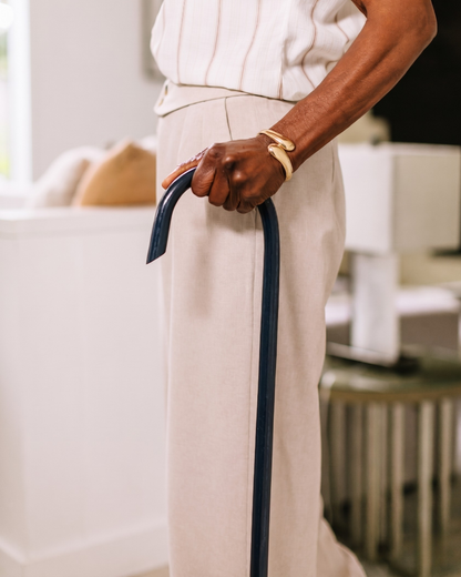 Close-up of a person holding a Navy Blue 7/8" Classic American Walking Cane indoors